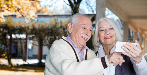 Happy retired couple in 70s outdoor relaxing