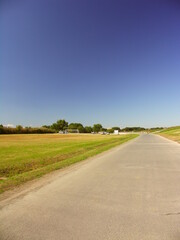秋の江戸川河川敷の舗装路とサッカー場風景