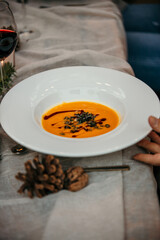 White plate on a table of freshly cooked pumpkin potage served whit a style by the chef.