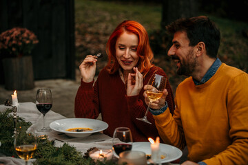 Smiling man and woman removing used soup potage plates and taking them into the kitchen. 