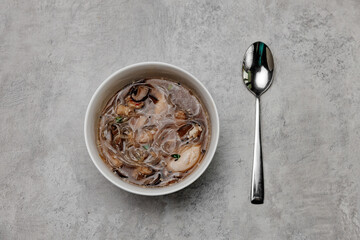 Udon soup with shrimps on a gray background. View from above.
