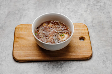 Udon soup with shrimps on a gray background. Close-up.
