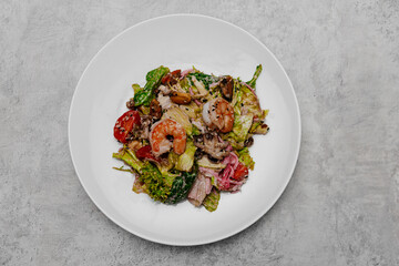 Salad with seafood on a gray background. View from above.
