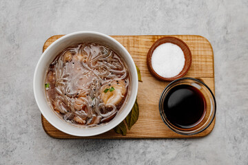 Udon soup with shrimps on a gray background. Close-up.
