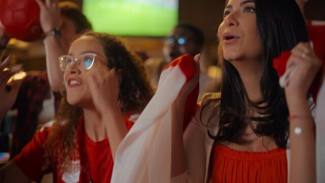 Close Up Portraits of a Diverse Group of Supportive Soccer Fans with Painted Faces Standing in a Bar, Cheering for Their Team. Raising Hands and Shouting. Friends Celebrate Victory After the Goal.