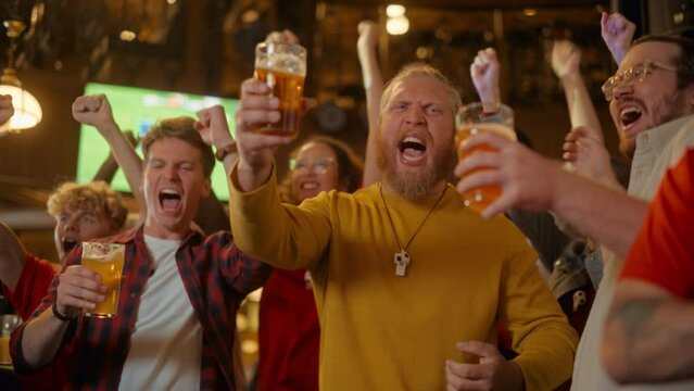 Group of Friends Watching a Live Soccer Match on TV in a Sports Bar. Three Men Cheering and Shouting. Young People Celebrating and Toasting Beer Glasses When Team Wins the Football World Cup.