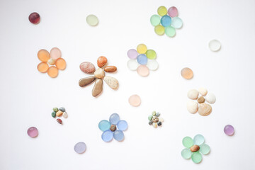 Art floral still life with glass, pebbles and stone flowers on white paper