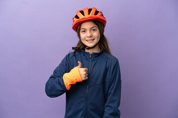 Little caucasian girl isolated on purple background giving a thumbs up gesture