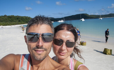 Obraz premium Selfie of a happy caucasian couple on vacation relaxing on a beautiful tropical beach
