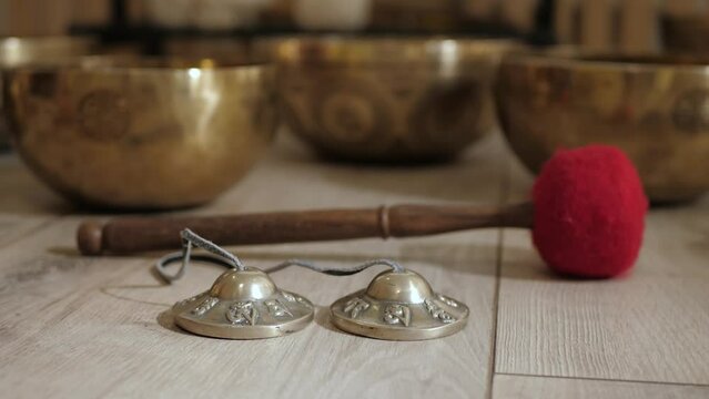 Small Tibetan singing bowls and mallet on the floor closeup