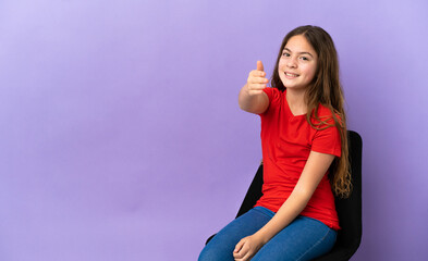 Little caucasian girl sitting on a chair isolated on purple background shaking hands for closing a good deal