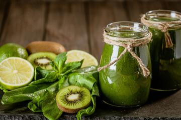 Closeup of fresh green smoothie in glass jars with lime. Detox concept. Good food