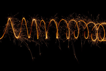 Spiral lights with sparks on a black background. Christmas lights on a long exposure.