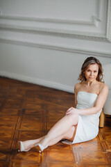 a delicate middle-aged woman in a white dress on the floor