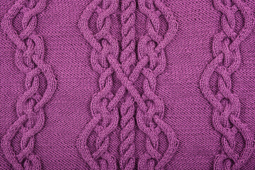 Knitted lilac background. Large knitted fabric with a pattern. Close-up of a knitted blanket. Horizontal ornament.