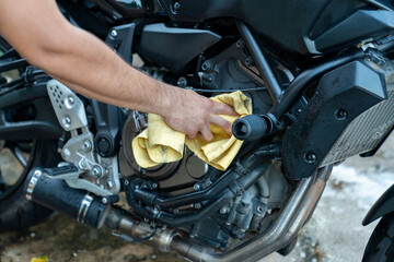 Fototapeta na wymiar Biker cleaning motorcycle by microfiber cloth.