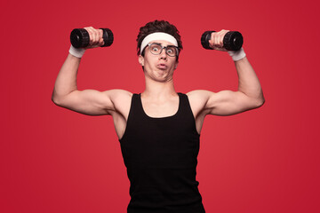 Funny nerd exercising with dumbbells