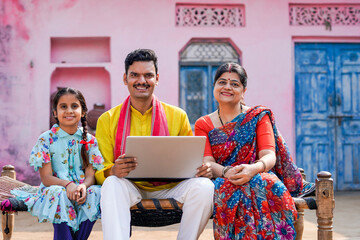 Indian rural family using laptop at home.