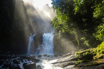 powerful nauyaca waterfall in costa rica at sunrise, large tropical waterfall in costa rica rainforest © Lens Down Under