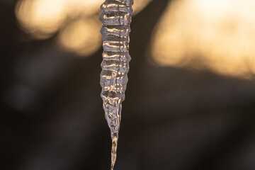 Ice cone hanging down from a roof of a house 