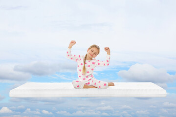 Healthy sleep. Little girl waking up on comfortable mattress in blue sky