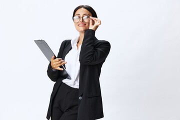 Business woman with a folder of documents in her hands in a black business suit and glasses shows signals gestures and emotions on a white background, work freelancer online training