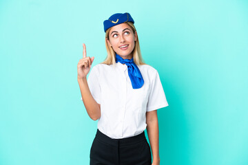 Airplane stewardess Uruguayan woman isolated on blue background pointing up and surprised