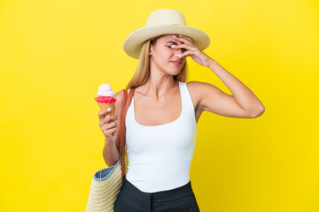 Blonde Uruguayan girl in summertime holding ice cream isolated on yellow background with headache