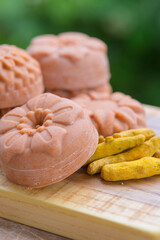  Round orange soap close up in the form of flowers with turmeric on a green background