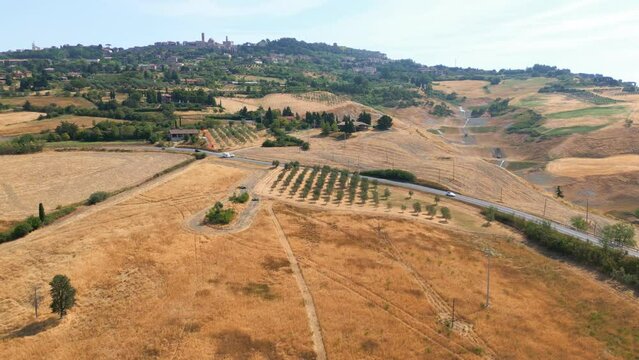 Aerial view of the village of Volterra, Italy. Vineyard and roads are seen in the foreground.