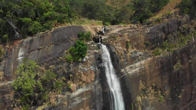 Girl stay on edge of cliff. Diyaluma Falls, Kostanda, highest waterfall in Sri Lanka. Drone footage 4K