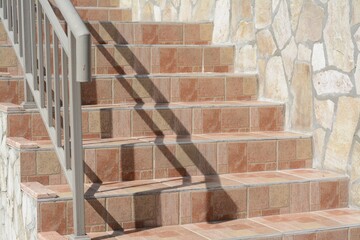 Beautiful tiled stairs with metal railings outdoors