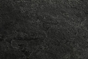 Texture of dark grey stone surface as background, closeup