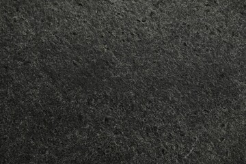 Texture of dark grey stone surface as background, closeup