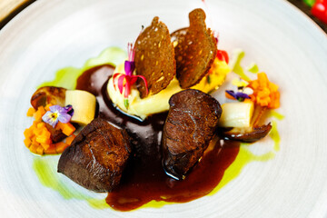 Deer tenderloin. Truffle-potato puree, porcini mushrooms, baked leek and carrot, juniper bread, port wine sauce. Delicious healthy traditional food served for lunch in modern gourmet restaurant