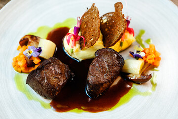 Deer tenderloin. Truffle-potato puree, porcini mushrooms, baked leek and carrot, juniper bread, port wine sauce. Delicious healthy traditional food served for lunch in modern gourmet restaurant