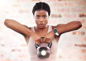 Black woman, fitness and kettlebell with focus and exercise in gym, weights and muscle training...