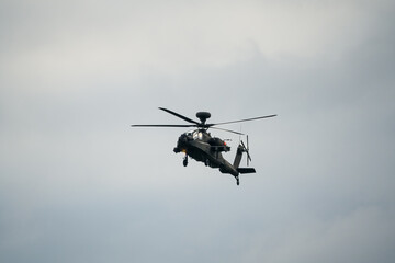 Fototapeta na wymiar British army AH-64E Boeing Apache Attack helicopter (ZM722 ArmyAir606) on landing approach, autumn sky
