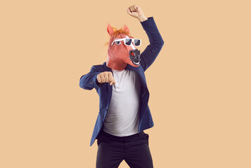 Funny unrecognizable man in rubber horse mask is fooling around dancing in gangnam style. Cheerful...
