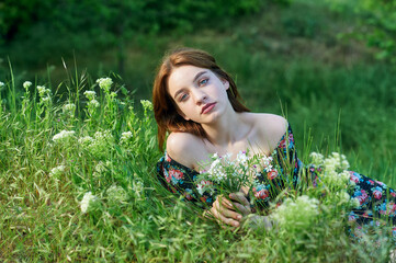 Young beautiful girl lies on the green grass. Girl enjoying summer day - 552591418