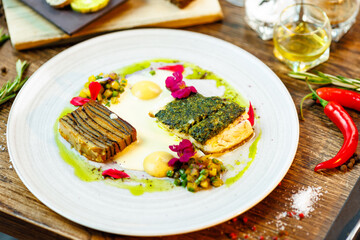 Pike-perch fillet. Potato gratin, warm yellow beet-turkey bean salad, parmesan dressing. Delicious seafood fish closeup served on a table for lunch in modern cuisine gourmet restaurant