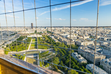 View on the city of Paris through the metal protective grid of the second floor of the Eiffel Tower