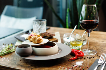 Beetroot soup Borscht with meat and sourcream in a bowl. Delicious healthy Ukrainian traditional food closeup served for lunch on a table in modern gourmet cuisine restaurant