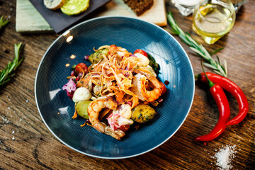 Warm salad with Argentinian king prawns. Almond potato, mini romaine lettuce, carrot, cherry tomato, pesto, black root chips, caramelized walnut, beet balsamic. Food served in modern restaurant