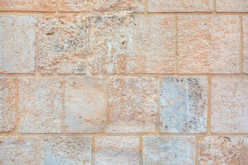 Close-up shot of ancient beige   brick wall background - Aged  natural stonewall