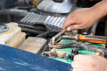 Hands of car mechanic in auto repair service