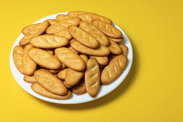 Salty crackers on a Senior Batonio plate on a yellow background