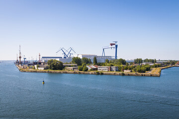 Fototapeta na wymiar Industrial area in Rostock port harbor with cranes, facilities and docks