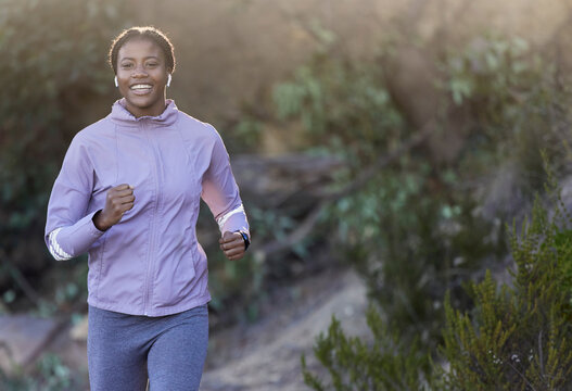 Black woman, running and fitness of a runner happy about nature workout and sport. Training motivation, cardio and exercise for a marathon run on a mountain bush hiking path outdoor for health