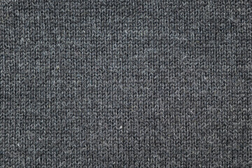 Surface of warm winter knitted gray sweater as background or texture, top view